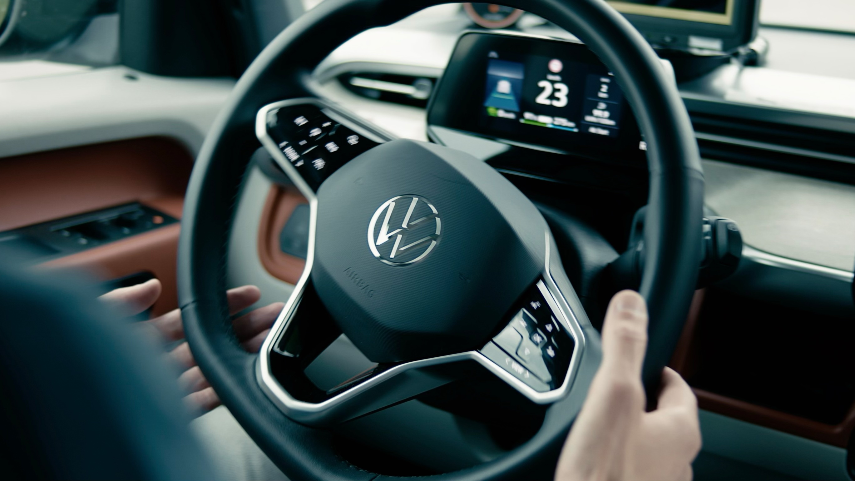 Volkswagen car interior showing steering wheel with logo and digital dashboard displaying speed and driving data