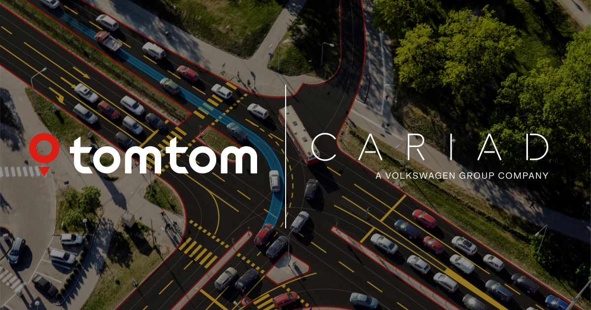 Aerial view of a busy multi-lane intersection with highlighted navigation paths and traffic flow visualization, featuring TomTom and CARIAD logos to represent smart routing and connected car technology.