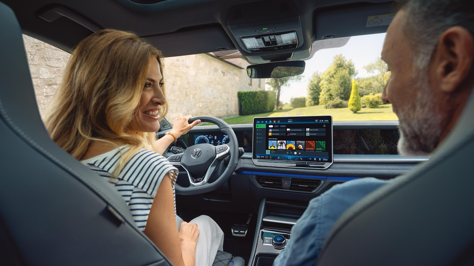 Interior view of a Volkswagen vehicle featuring a modern infotainment system with touchscreen display, showing apps and navigation options, highlighting connected car technology and digital cockpit design.