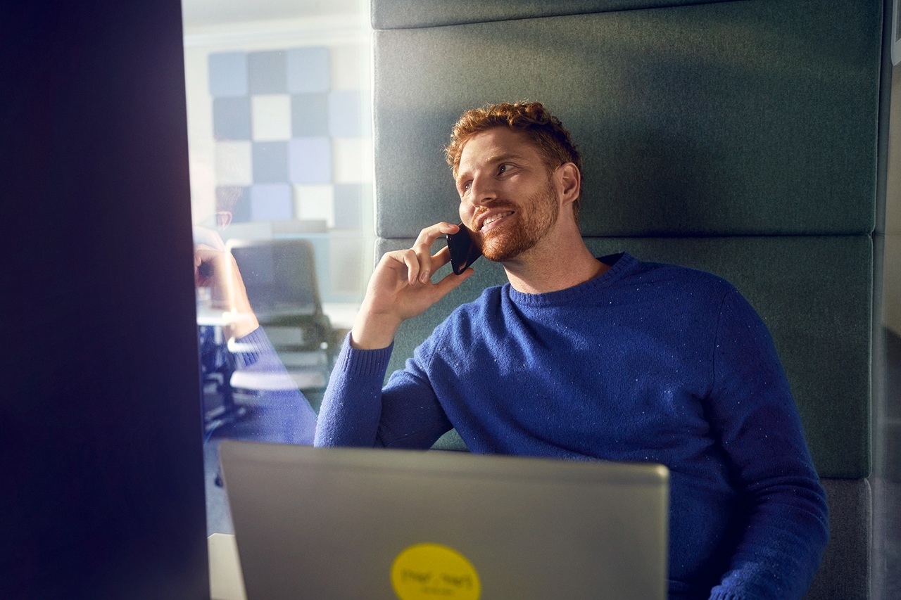Our locations men with blue pullover in phone booth