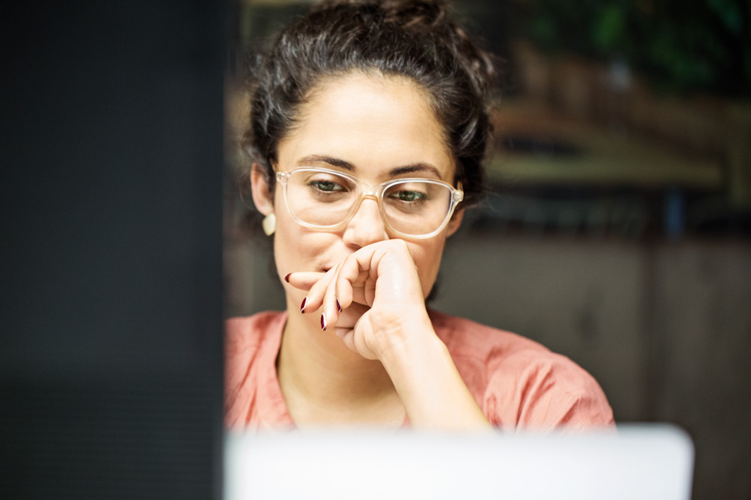 867421140 Thoughtful young businesswoman using computer in office