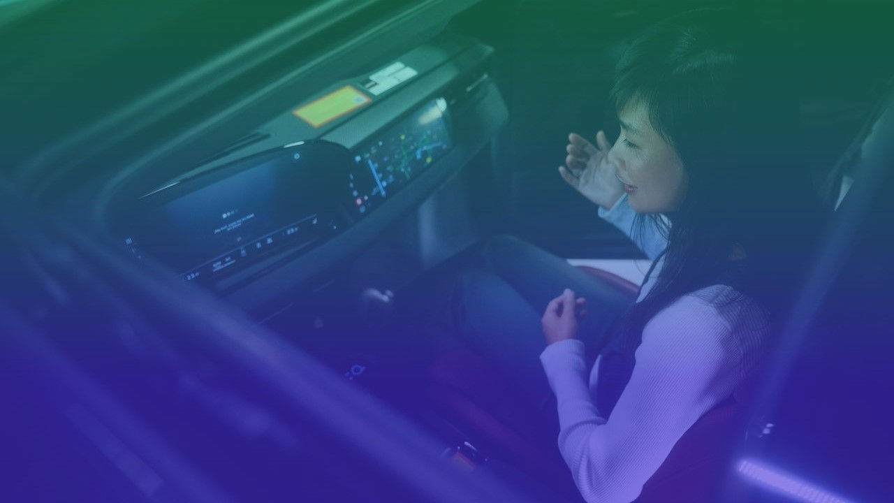 How AI becomes one of your car’s smartest features Person in passenger seat of a car with dashboard and infotainment system visible